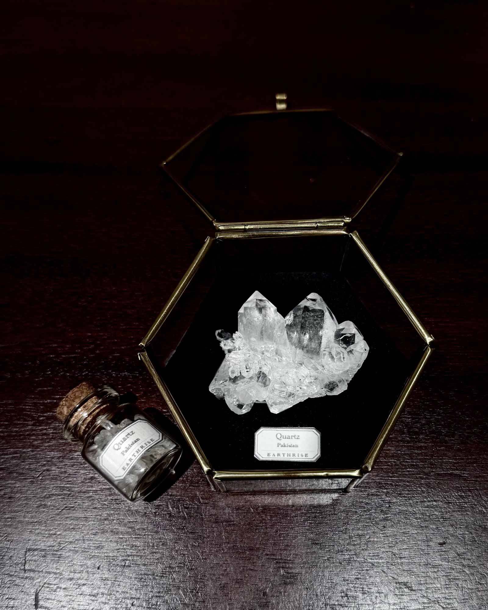 ヒマラヤ産の虹色の輝きが見える鉱物標本（真鍮のガラスケース入り）と、ヒマラヤ水晶の原石すくい用ガラス瓶